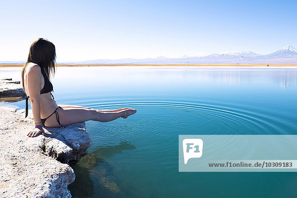 Chile  Atacama-Wüste  Frau im Bikini  die ihre Füße in Laguna Cejar taucht