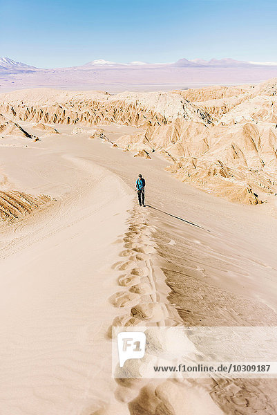 Chile  Atacama Desert  man climbing a dune