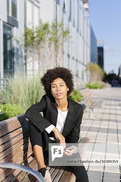 USA  New York City  businesswoman relaxing on a bench