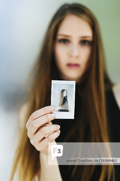 Junge Frau mit einem Polaroid in der Hand