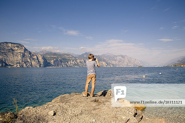 Italy  Veneto  Brenzone sul Garda  Boy taking pictures with smartphone