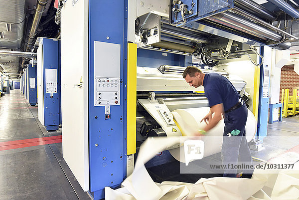 Man working at printing machine in a printing shop