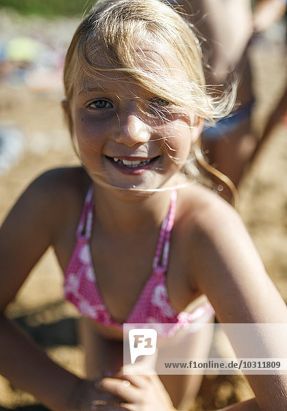 Porträt eines lächelnden kleinen Mädchens am Strand