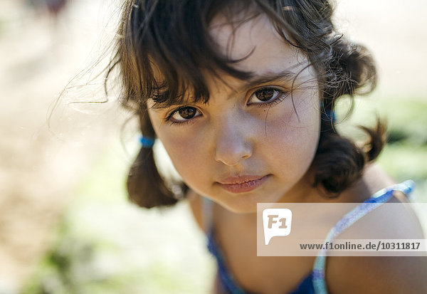 Porträt eines ernsthaft aussehenden kleinen Mädchens am Strand