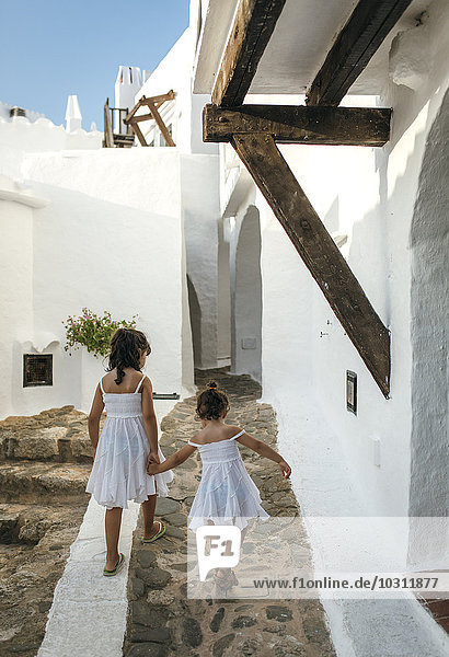 Spanien  Balearen  Menorca  Binibeca  Rückansicht zweier kleiner Schwestern  die Hand in Hand gehen