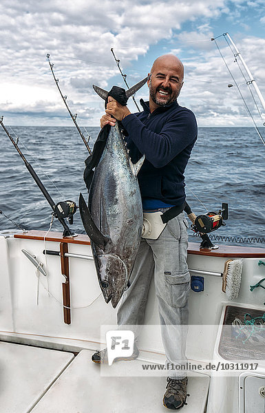 Spain  Asturias  Fisherman holding freshly caught tuna