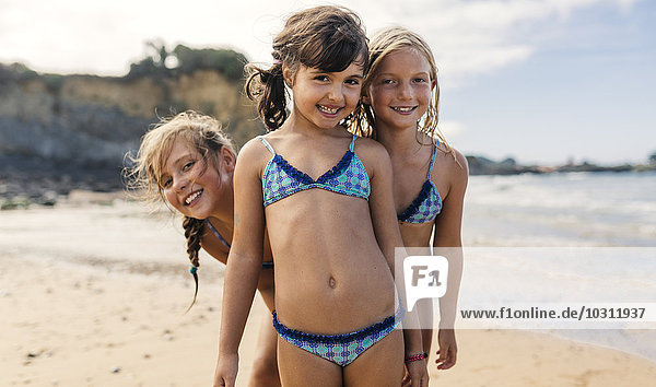 Spain  Colunga  three happy girls on the beach