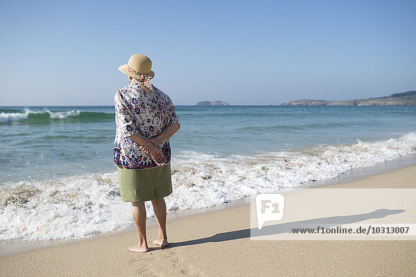 Spanien  Ferrol  Rückansicht einer älteren Frau am Strand