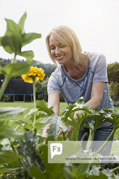 Lächelnde Frau bei der Arbeit im Garten