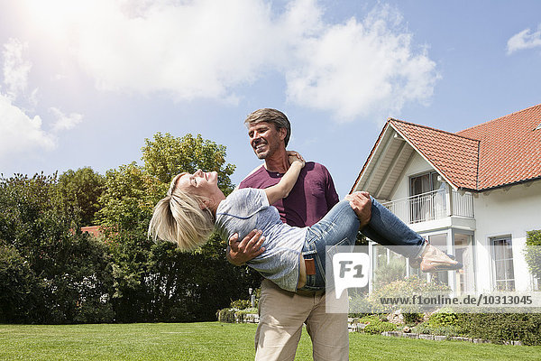 Glücklicher Mann mit Frau im Garten