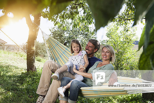 Happy family sitting in hammock