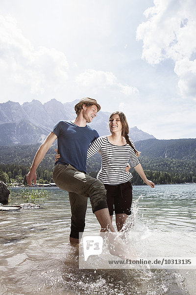 Germany  Bavaria  Eibsee  happy couple splashing in water