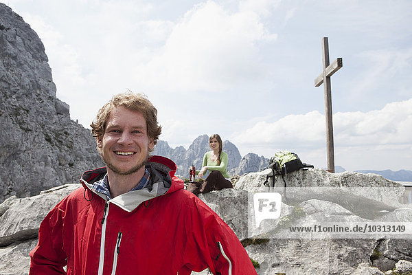 Deutschland  Bayern  Osterfelderkopf  Porträt eines lächelnden Wanderers mit Frau am Gipfelkreuz