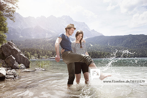 Germany  Bavaria  Eibsee  happy couple splashing in water