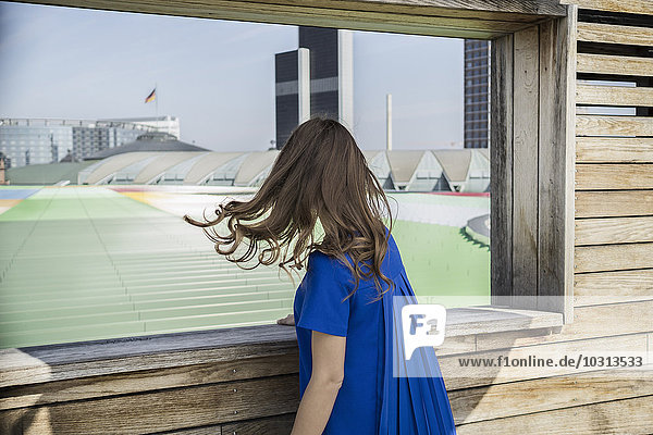 Deutschland  Frankfurt  Geschäftsfrau im blauen Kleid mit Blick auf die Aussicht