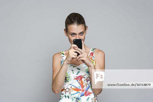 Young woman photographing with smartphone