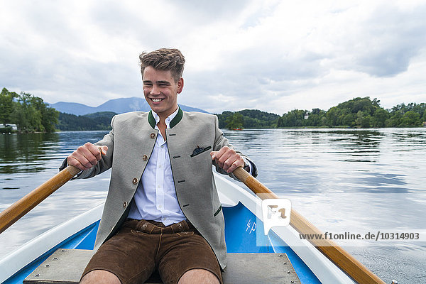Deutschland  Bayern  Porträt eines lächelnden jungen Mannes am Staffelsee