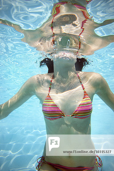Körper einer jungen Frau unter Wasser im Schwimmbad