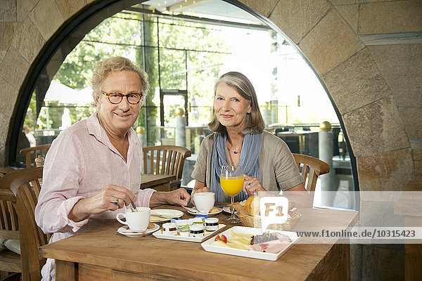 Lächelndes Seniorenpaar beim Frühstück im Cafe
