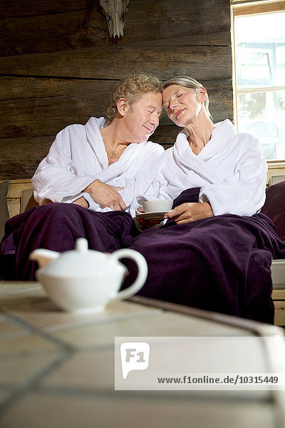 Entspanntes Seniorenpaar im Bademantel auf der Bank sitzend