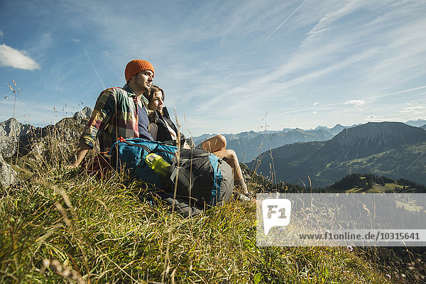 Österreich  Tirol  Tannheimer Tal  junges Paar beim Ausruhen in den Bergen