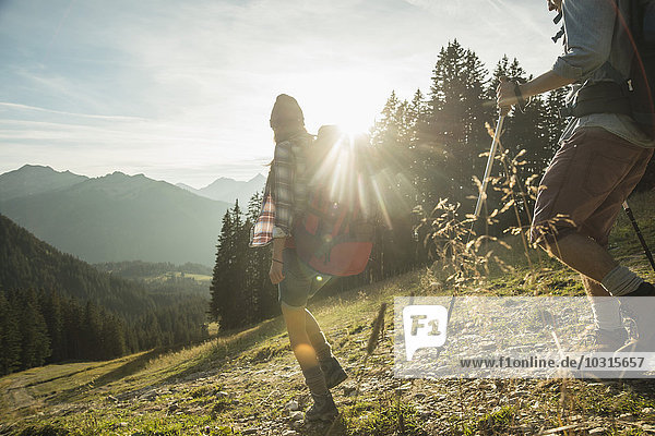 Österreich  Tirol  Tannheimer Tal  junges Paar beim Sonnenwandern auf der Alm