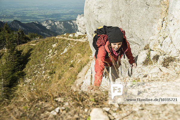 Austria  Tyrol  Tannheimer Tal  young woman hiking on rock