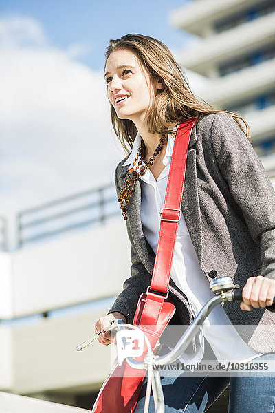 Lächelnde junge Frau mit Fahrrad