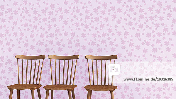 Reihe von drei Holzstühlen vor rosa Tapete mit Blumenmuster