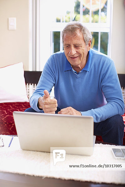 Senior Mann mit Laptop zu Hause