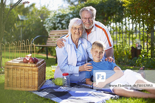 Grandparents with grandson having a picnic in park