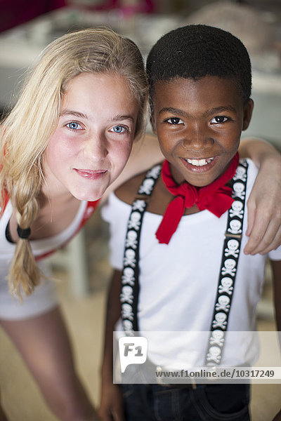 Portrait of smiling girl and boy in pirates suspenders