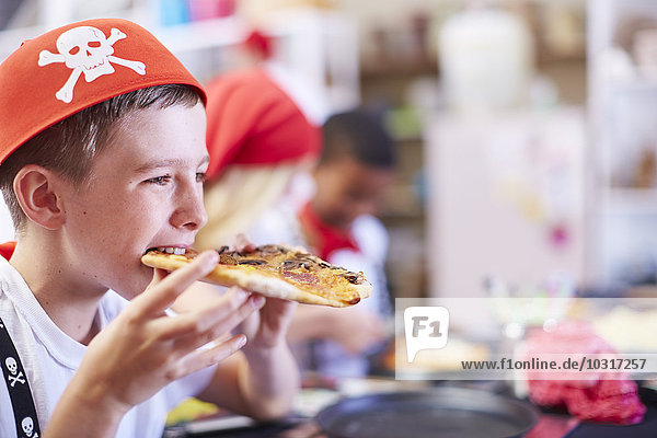 Boy dressed up as pirate eating pizza on a party