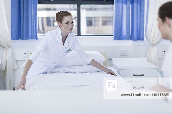 Zwei Krankenschwestern machen das Bett des Patienten