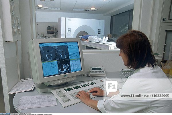 Krankenhaus  Patient wird zu einer Computertomografie in die CT-Röhre gefahren  Monitor kontrollieren