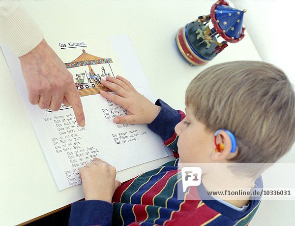 Gehörloser Junge im Vorschulalter liest Die Hörgeschädigtenschule Kreisverkehr Schwäbisch Gmünd