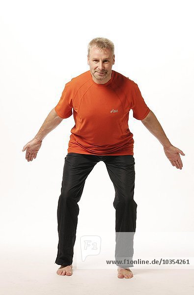 älterer Mann stehend mit geöffneten Beinen und nach vorne gedrehtem Oberkörper und den Armen zum unteren Rücken gedreht - Grundstellung und Stellung beim Ausatmen