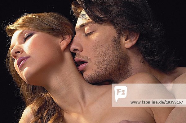 Young man kissing a young woman's neck