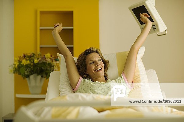 Frau streckt sich im Krankenhausbett