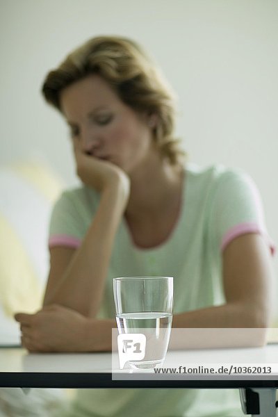 Glas Wasser vor einer Frau