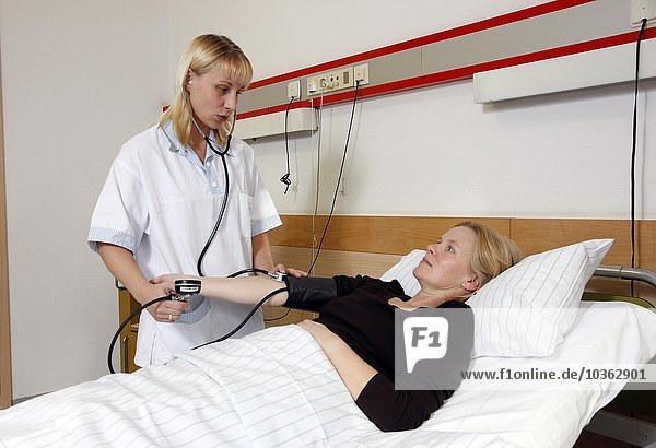 Die Krankenschwester prüft den Puls eines Patienten in einem Krankenhaus