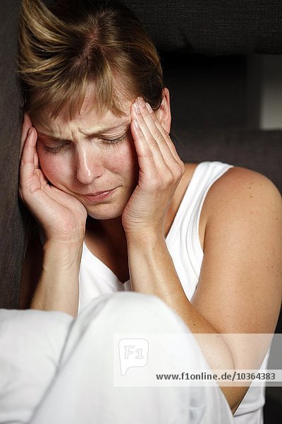 Junge erwachsene Frau hat Kopfschmerzen