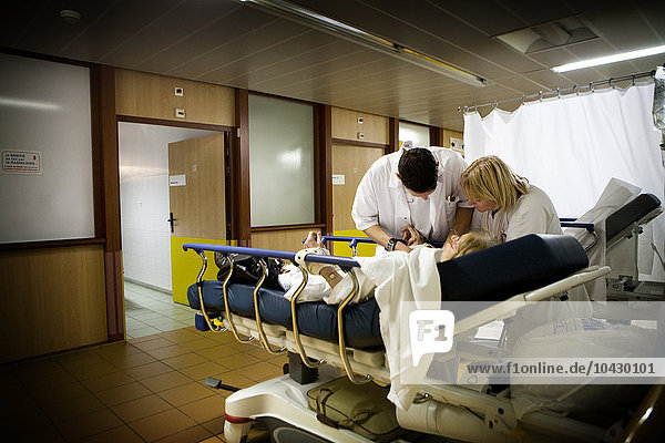 Reportage aus der Notaufnahme des Allgemeinkrankenhauses Robert Ballanger  Frankreich. Eine Krankenschwester und ein Praktikant mit einem Patienten.