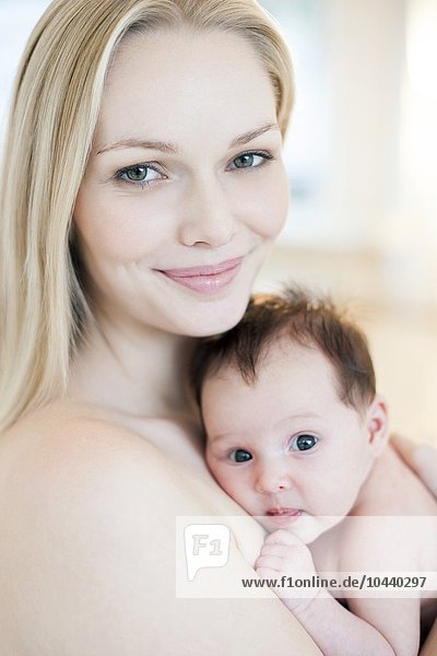 MODEL RELEASED. Mother and baby. Mother holding her 5 week old daughter. Mother and baby