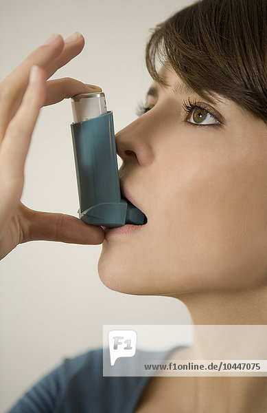 Junge Frau benutzt Inhalator