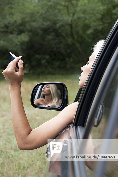 woman who smokes out the window of a car