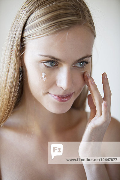 Frau trägt Gesichtscreme auf