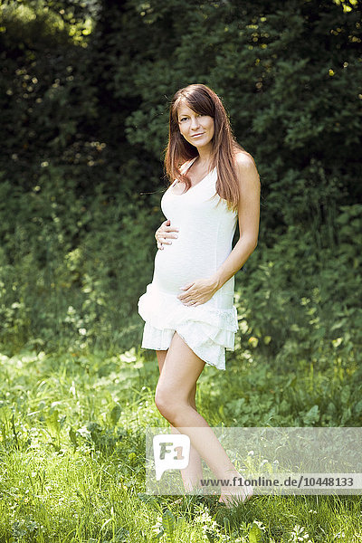 schwangere Frau im weißen Kleid