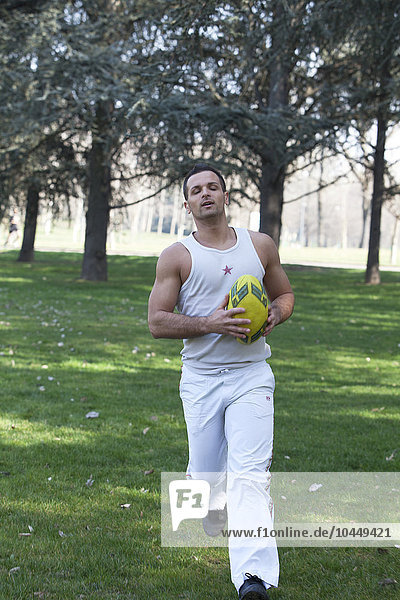 Mann spielt Fußball im Park