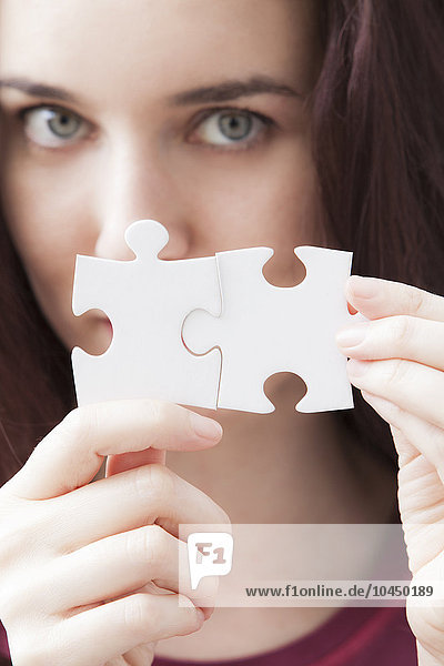 Frau mit zwei Teilen eines Puzzles